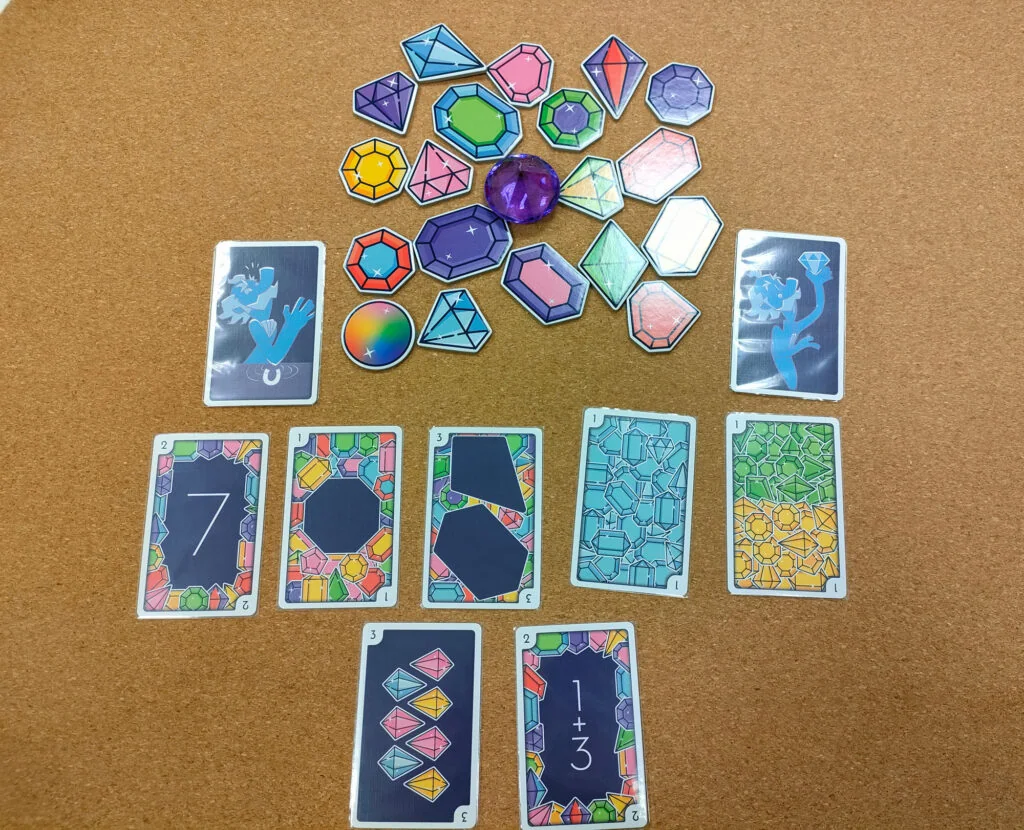 Ejemplo de gemas, cartas y maldiciones. La joya morada maldita está colocada en el centro de las gemas.